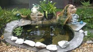 My cousin Jeannine's Heart fountain with a lip to the front beside her small fish pond, Melbourne, FL