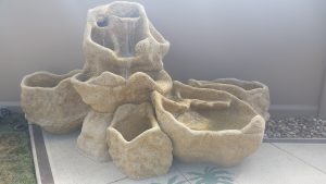 Large three piece fountain with lily pond base that raises the top piece to about 54" tall, with three adjacent oblong or Serenity shape planters.  Photo taken before the client planted the fountain.