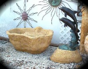 Double fountain spitter mounted on a base, designed to shoot into lily pond